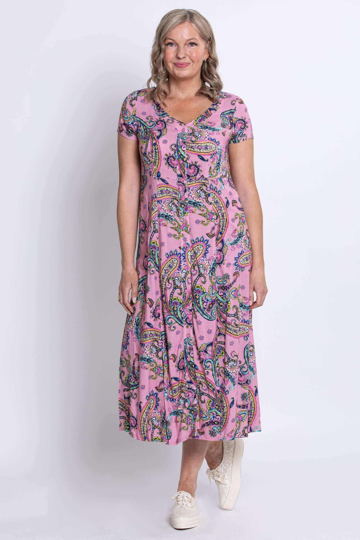 Front standing pose of woman in pink paisley midi dress