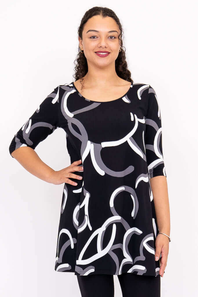 Front view of model wearing black A-line dress with white and gray abstract print