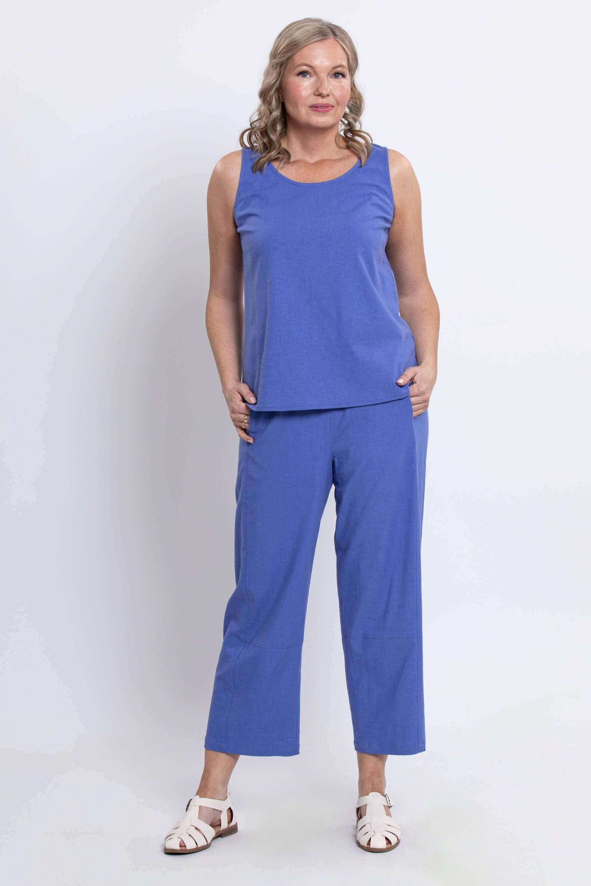 Front view of model wearing blue cropped pants with sleeveless top