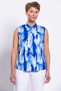 Front view of a woman wearing a sleeveless blue tie-dye button down blouse