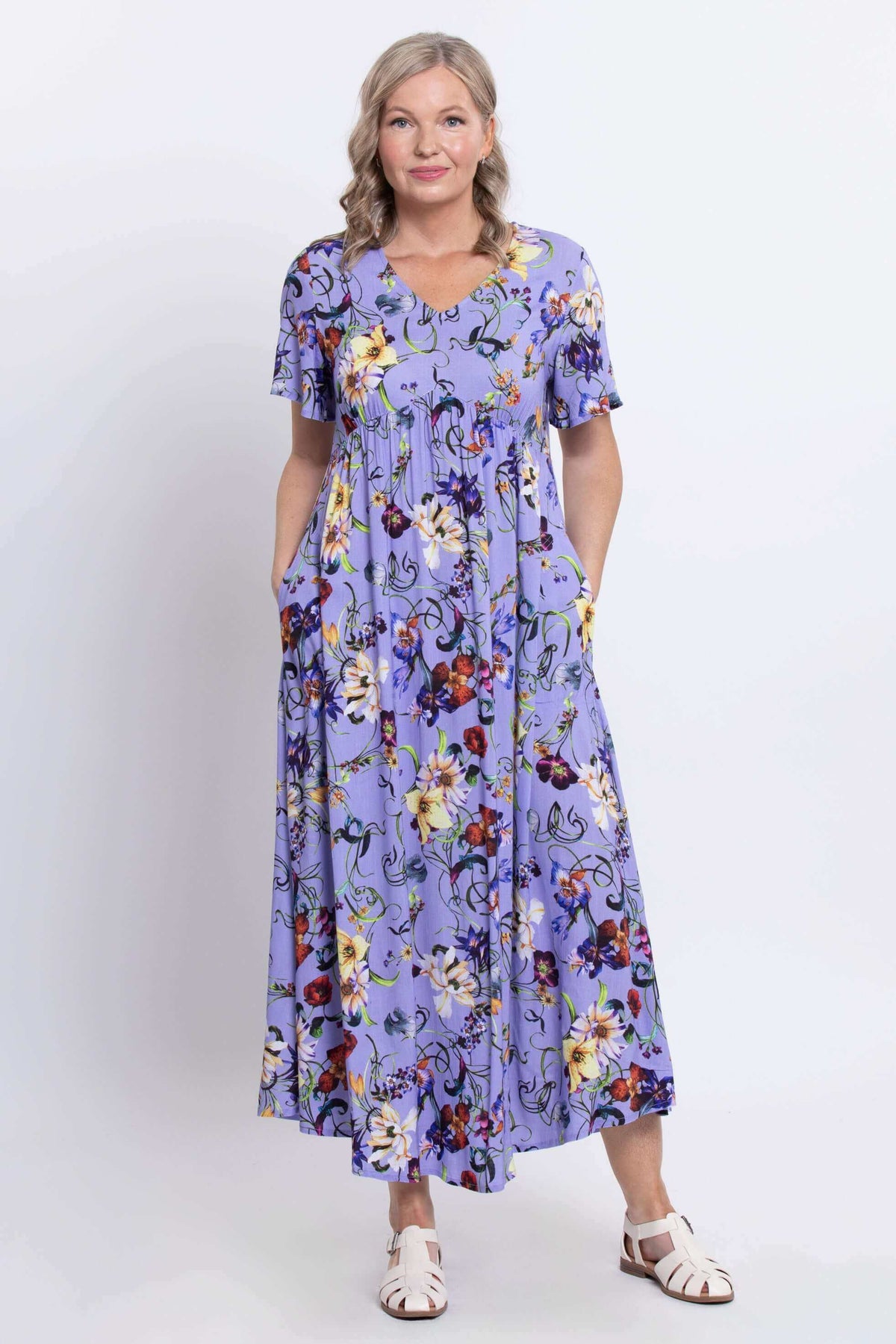 Front view of woman wearing a long violet floral empire waist maxi dress