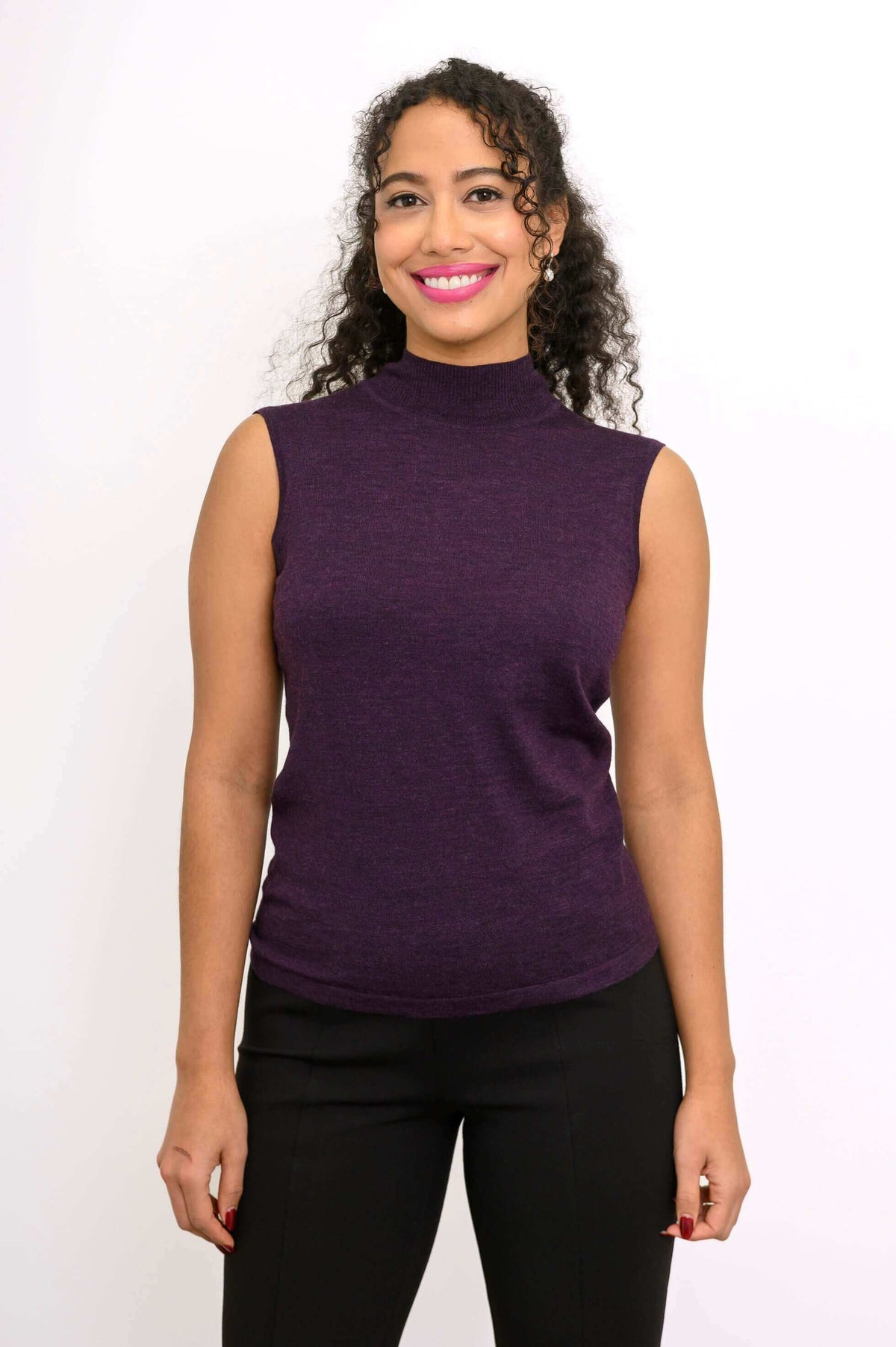 Front view of woman wearing sleeveless purple mock neck Merino wool sweater