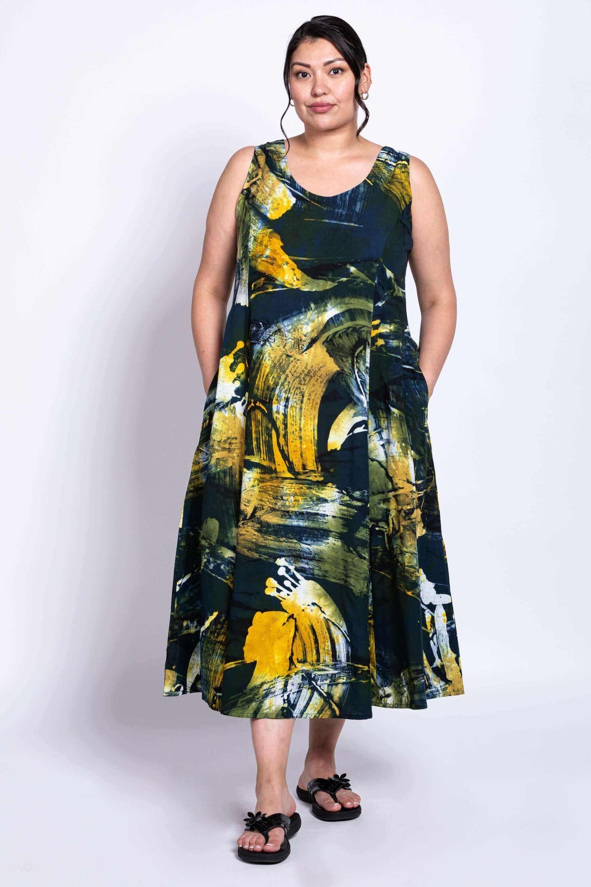 Front view of model wearing the Sara summer dress with abstract yellow, green, and blue print