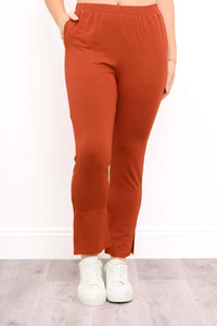 Front view of Sarina Bamboo Pant in rust with slim fit, elastic waistband, and slit ankle