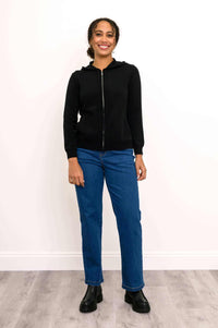 Woman facing forward in a black zip hoodie and straight-leg blue jeans