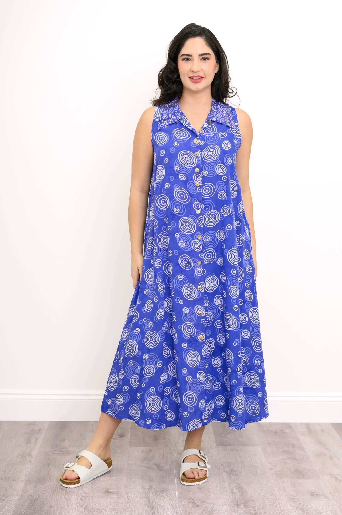 Front view of model wearing sleeveless blue A-line dress with white swirl pattern