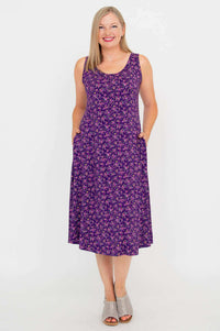Front view of woman wearing a purple floral Evangelina tank dress with pockets