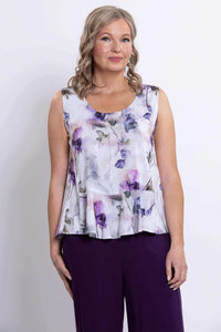 Front view of model wearing Ginny floral peplum tank top with purple pants
