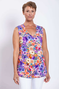 Front view of woman wearing vibrant floral sleeveless V-neck bamboo top