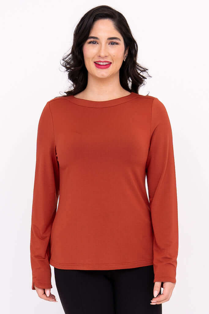 Front view of model wearing rust-colored Mona boat neck long sleeve top