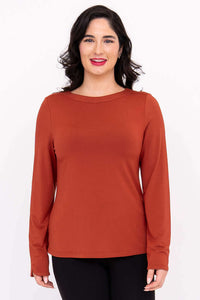 Front view of model wearing rust-colored Mona boat neck long sleeve top