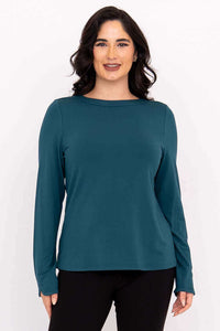 Front view of woman wearing teal Mona boat neck top with long sleeves