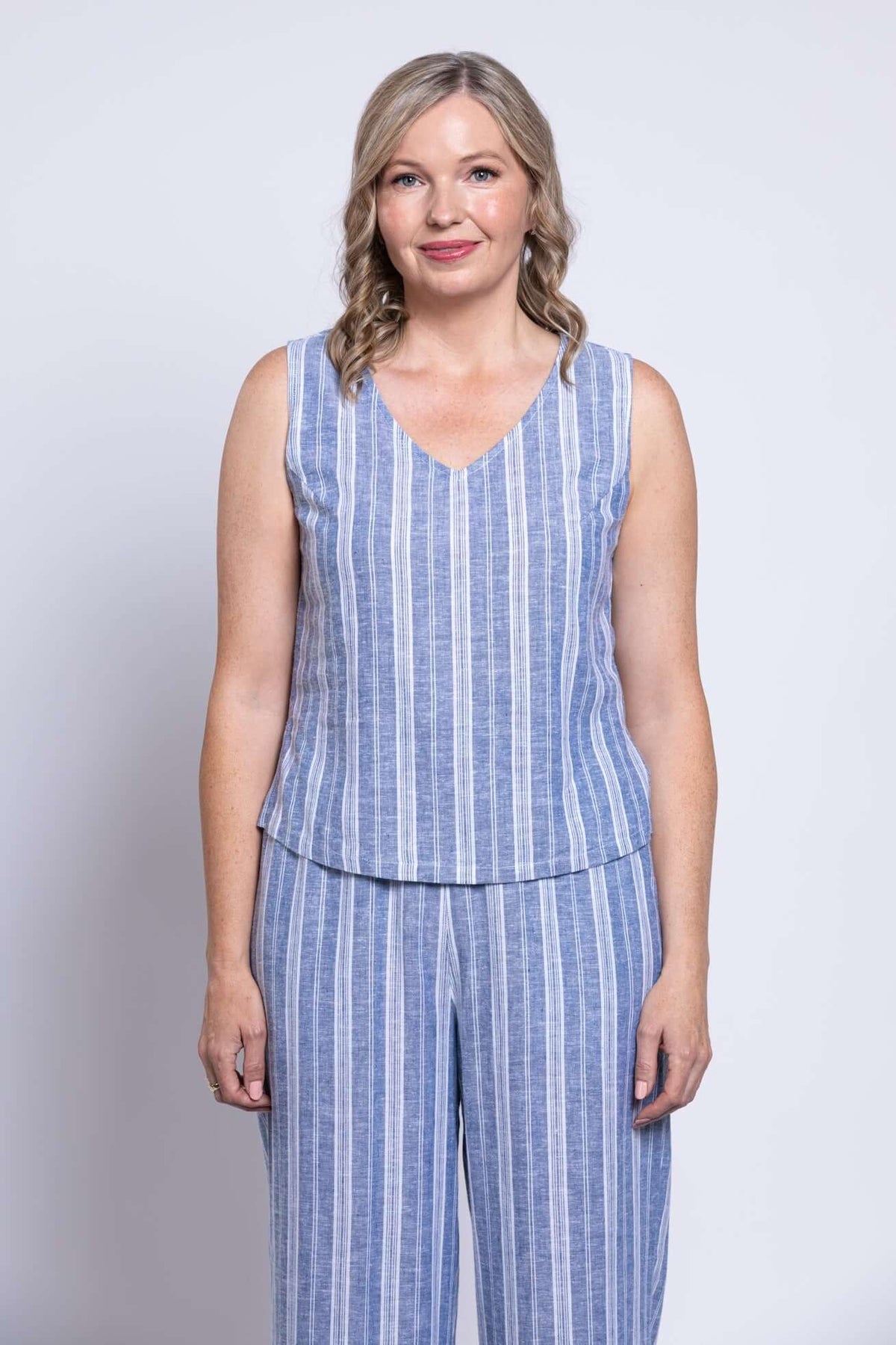 Front view of woman wearing blue and white vertical stripe sleeveless cropped tank