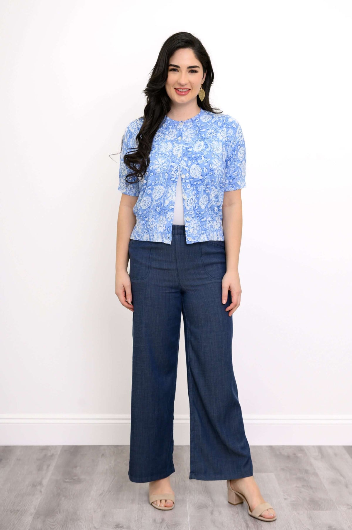 Front view of woman in blue floral cardigan and blue trousers