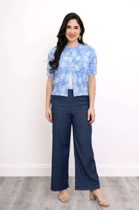 Front view of woman in blue floral cardigan and blue trousers