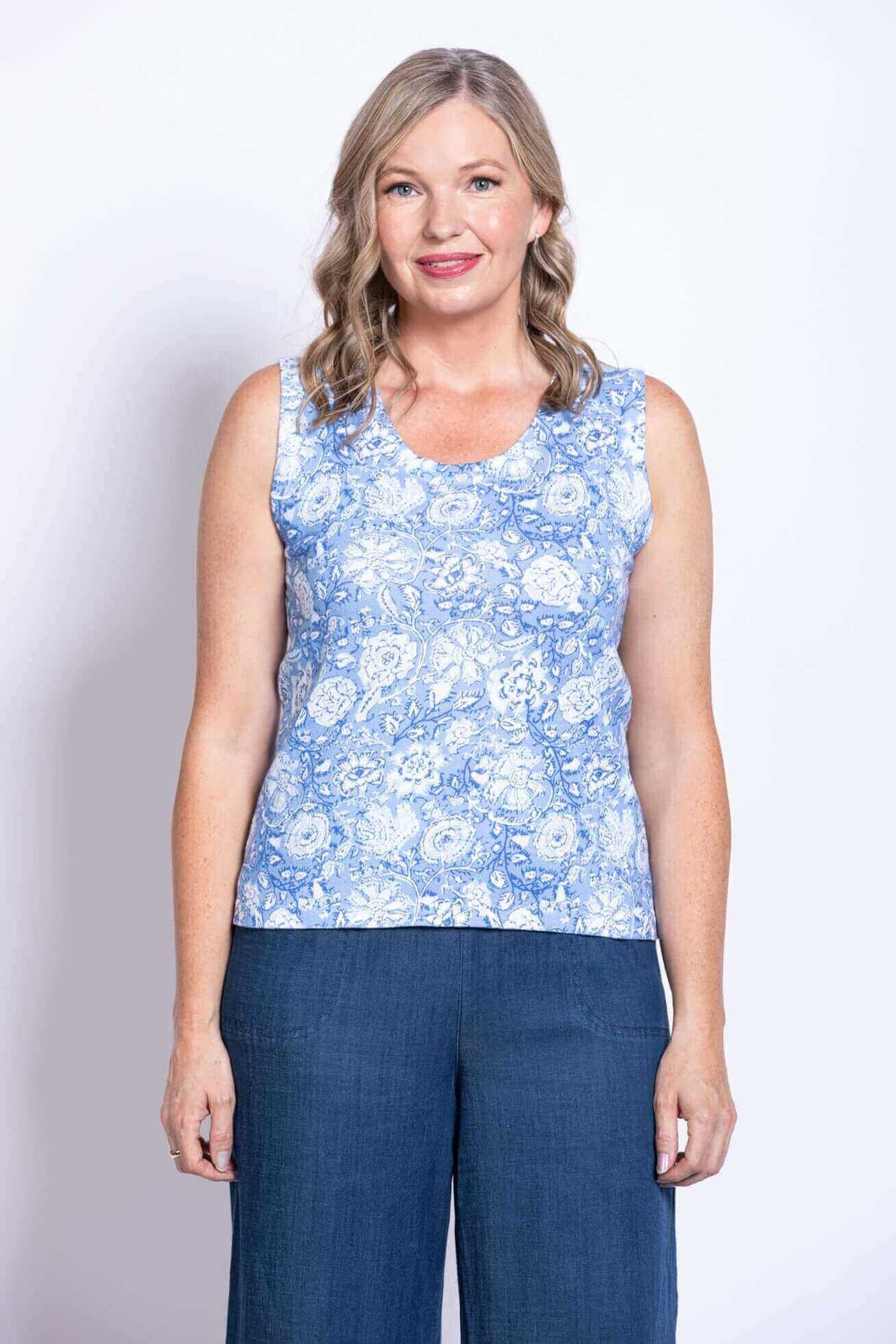 Front view of woman wearing a blue floral sleeveless tank top and blue pants