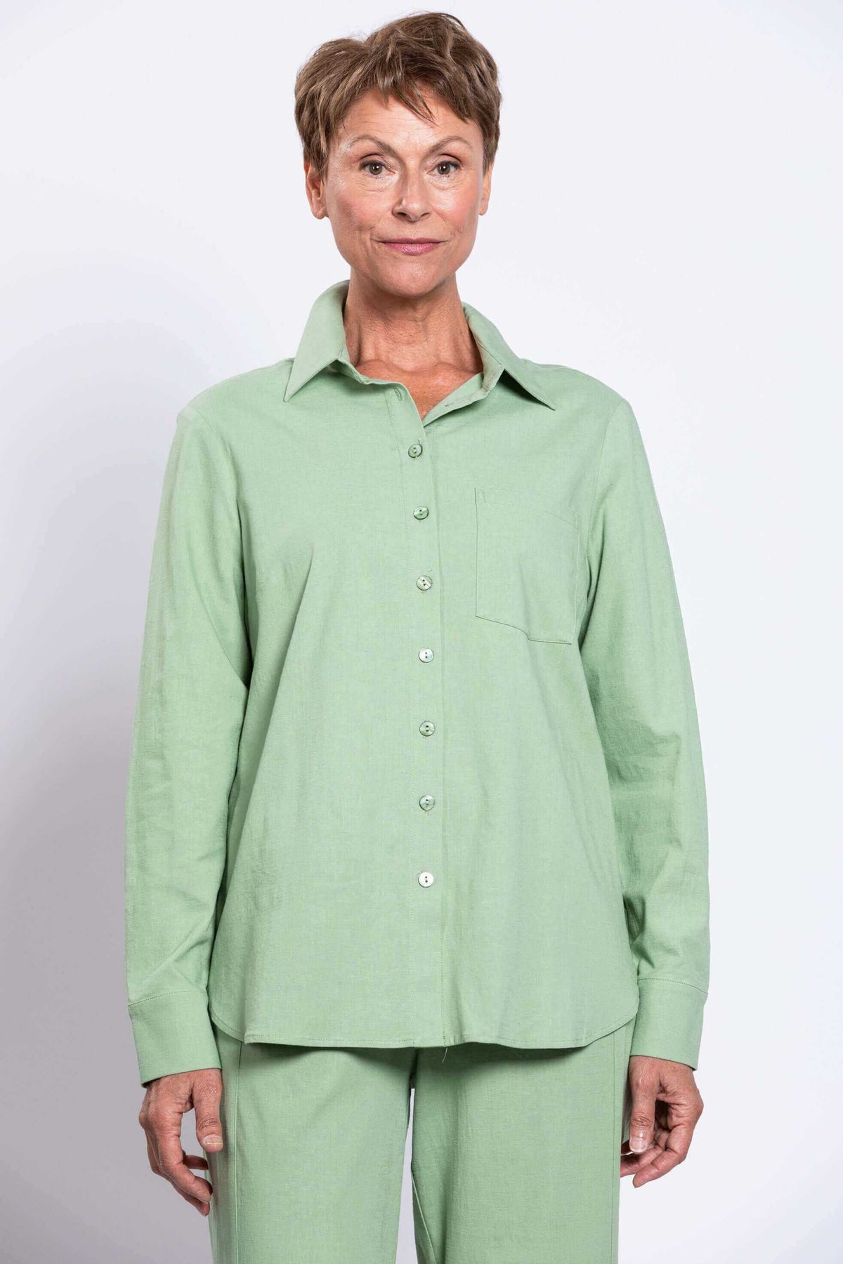 Front view close-up of woman wearing light green relaxed fit shirt and matching pants