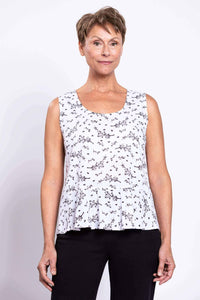 Front view close-up of woman wearing white floral sleeveless peplum tank top