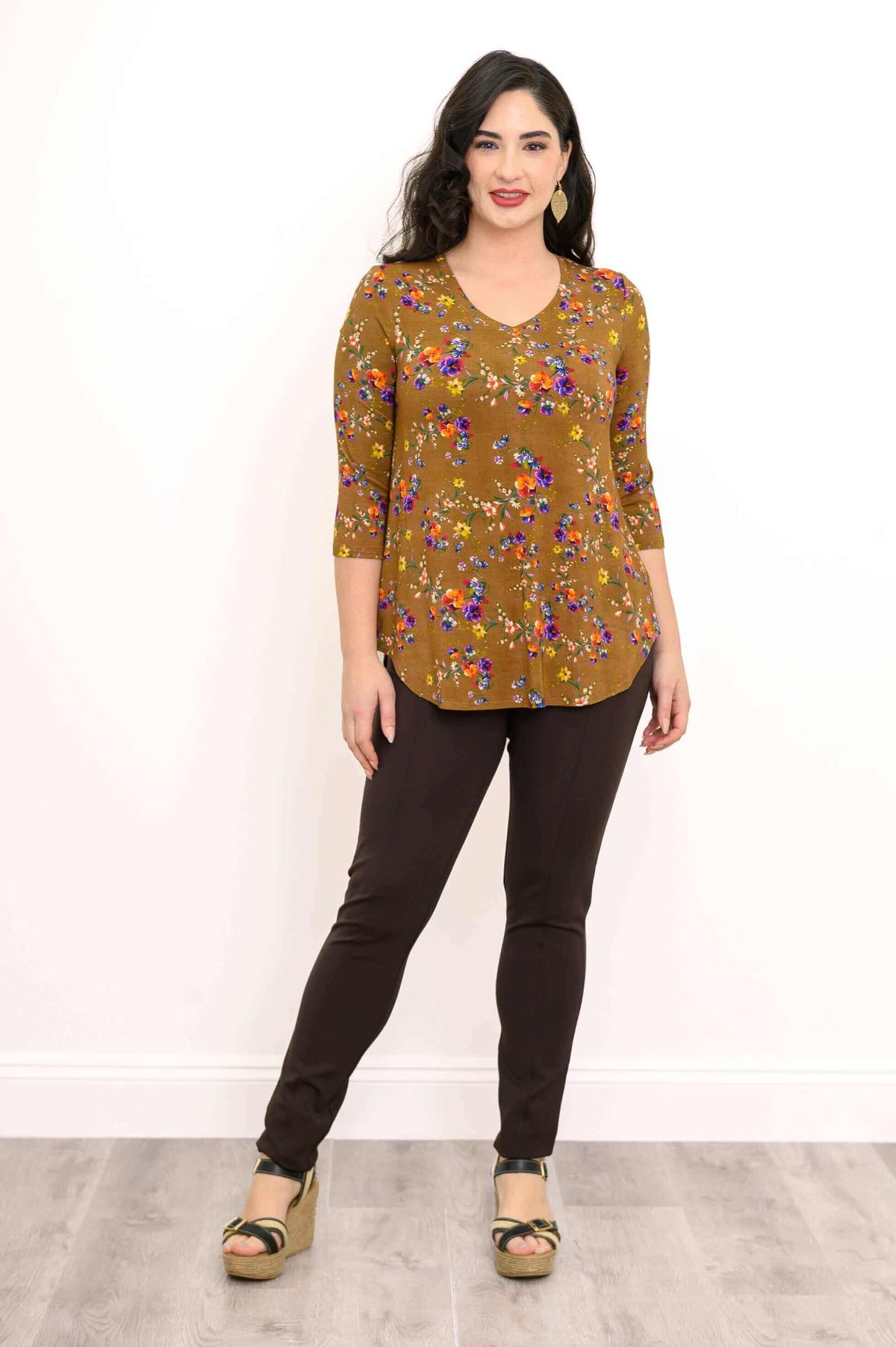 Woman facing forward in marigold floral V-neck bamboo top and brown pants