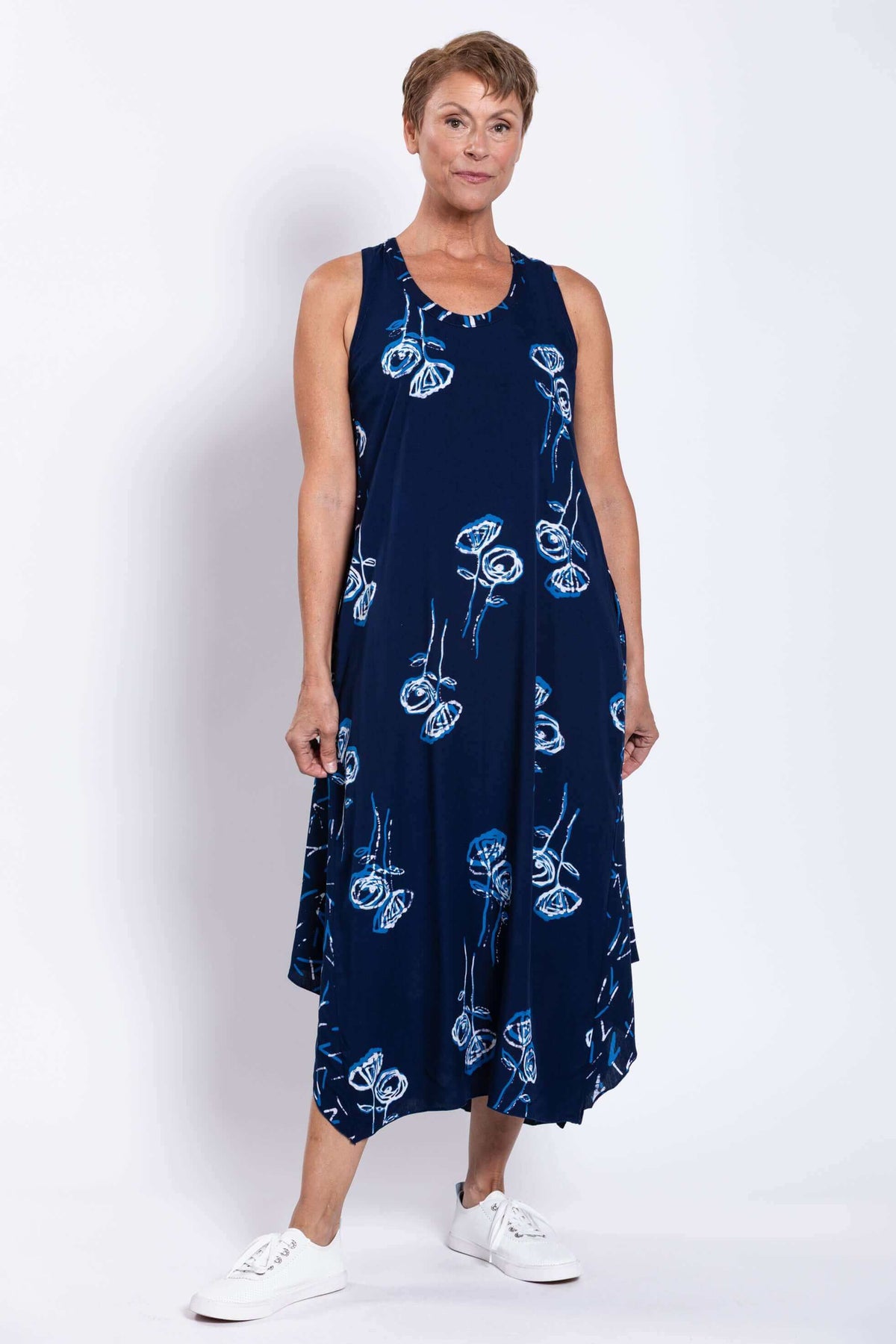 Front view of woman wearing navy blue floral midi tank dress with scoop neckline
