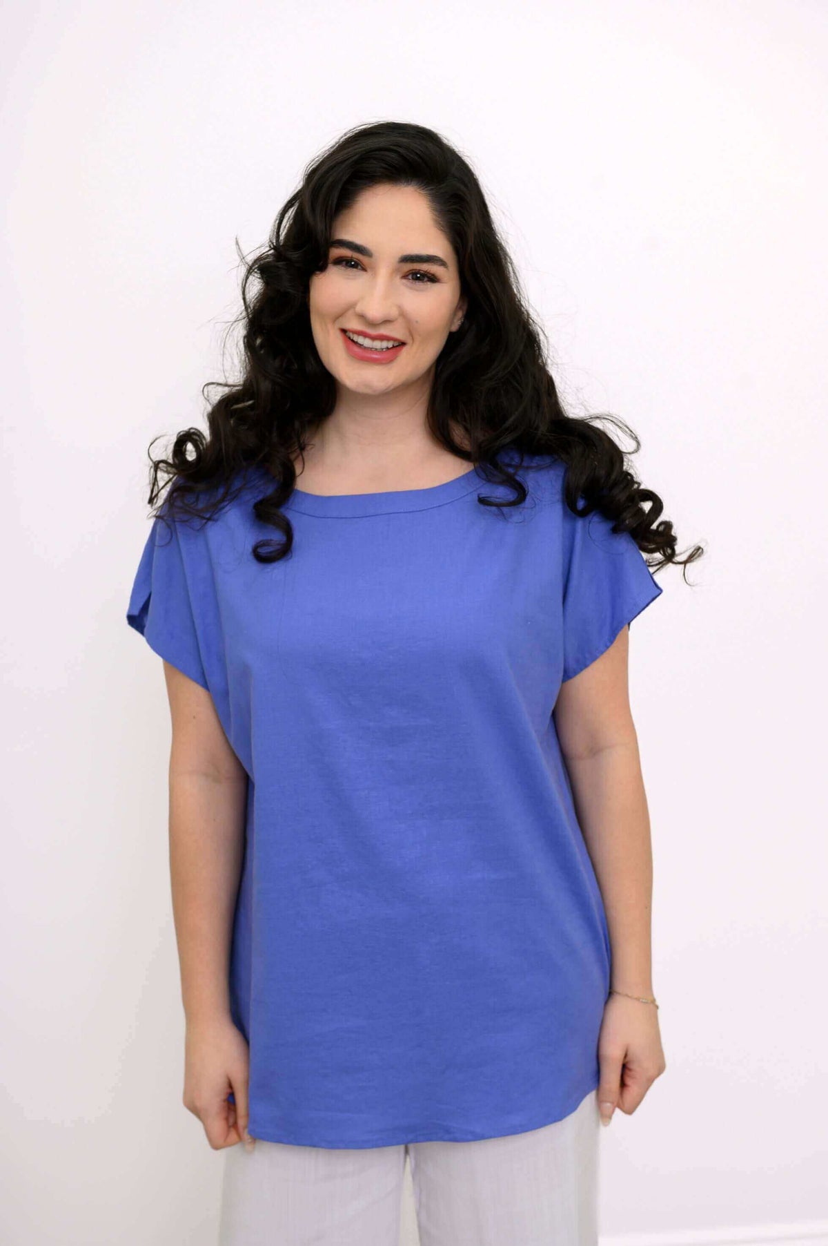 Front view of model wearing a blue Aria Tee with rounded boatneck