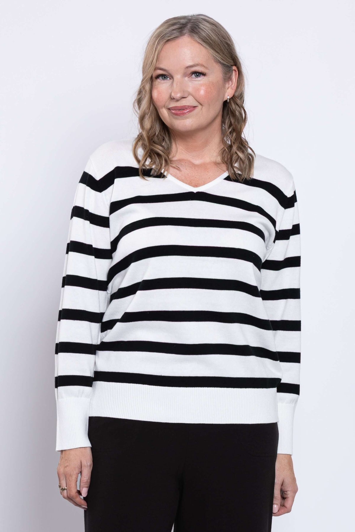 Front view of woman wearing Breton stripe V-neck sweater with black and tan stripes