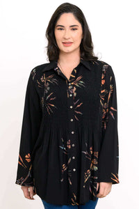 Front view of woman wearing a black long sleeve floral smocked tunic shirt