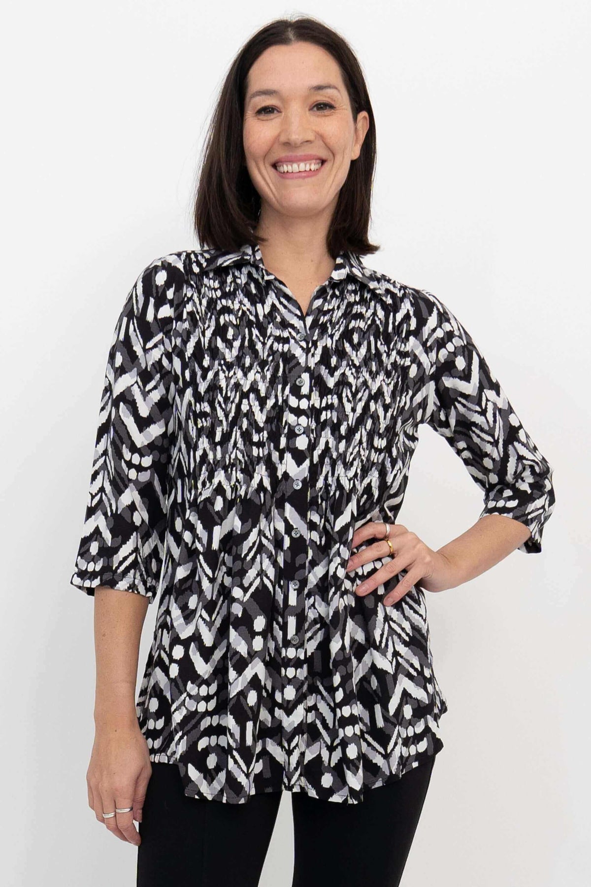 Front view of a woman wearing a black and white Ikat print blouse with 3/4 sleeves