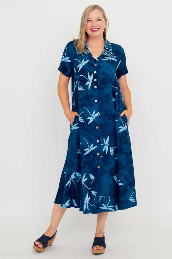 Front view of a woman wearing a blue A-line short sleeve dress with dragonfly print