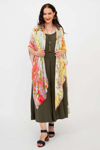 Front view of model wearing a colorful floral Darcy kimono wrap over an olive dress