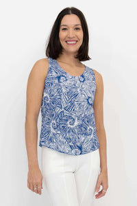 Front view of woman wearing blue swirl print sleeveless Dee Tank top with white pants