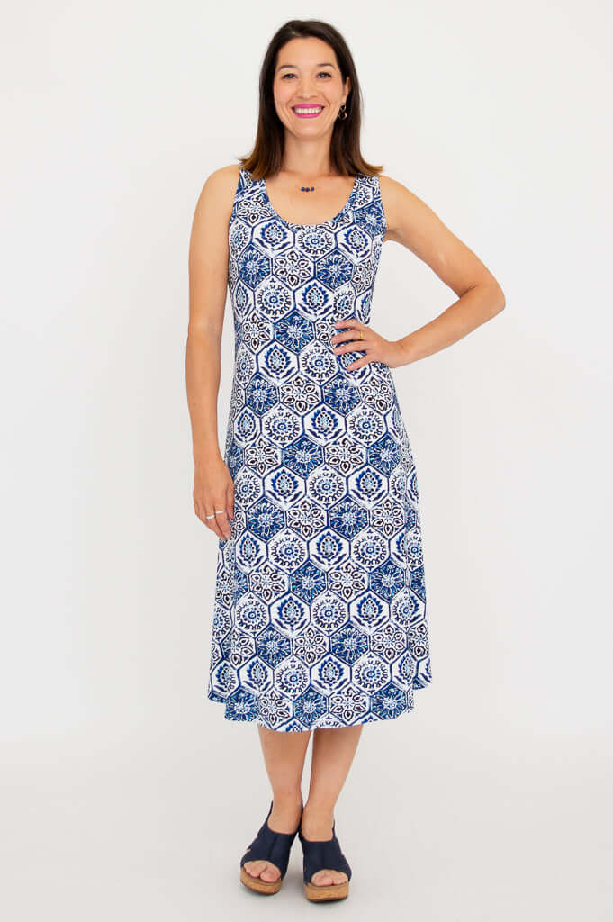 Woman wearing a sleeveless blue and white patterned tank dress, standing front facing