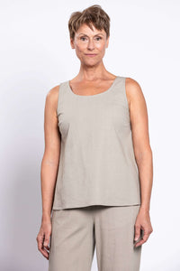 Woman wearing a sleeveless beige tank top and matching pants, front view