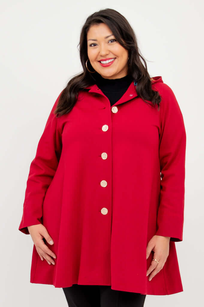 Front view of a person wearing a berry red swing coat with bold buttons