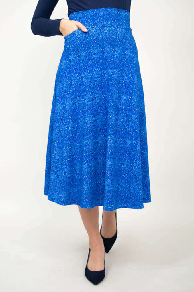 Front view of a woman wearing a blue patterned bamboo stretch skirt with pockets