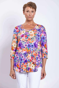 Front view of model wearing a colorful floral Jazz bamboo top with 3/4 sleeves