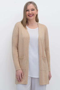 Front view of woman wearing beige Justine open cardigan sweater with patch pockets