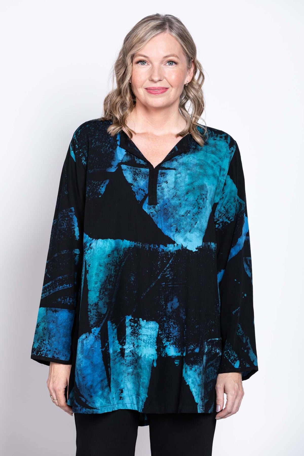 Front view of a woman wearing a black and blue abstract Batik blouse with a V-neck collar
