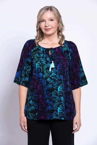 Front view of a woman wearing a Luna Boho Peasant Top with blue and purple print and tie-front detail