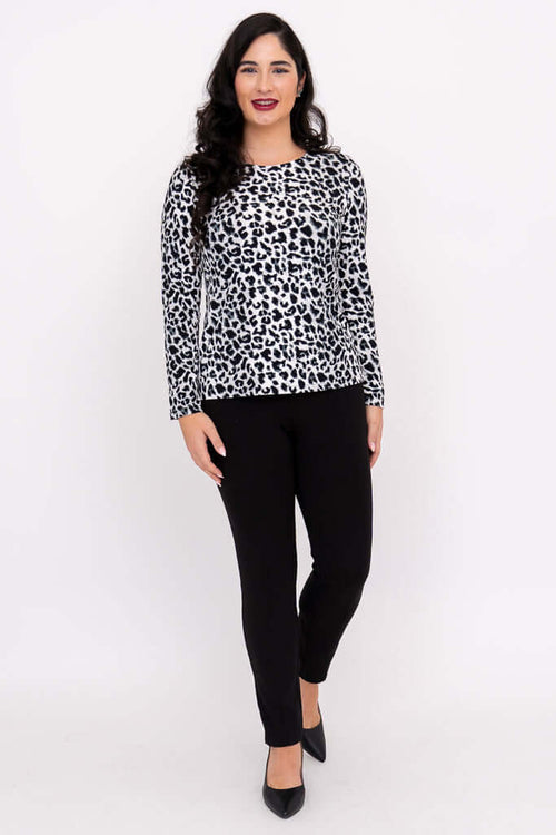 Woman wearing a long sleeve leopard print tee with black pants, standing front-facing