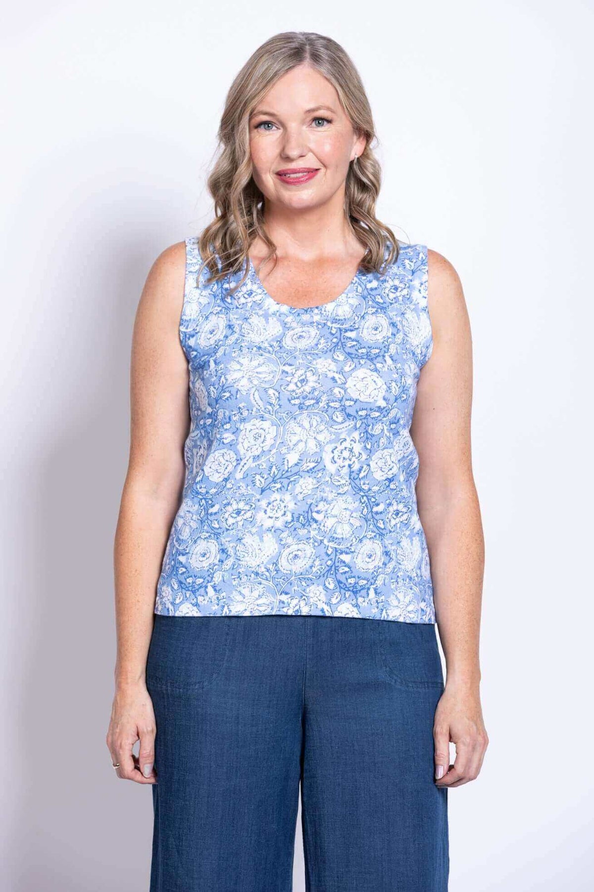 Front view of woman wearing blue floral tank top and wide-leg pants