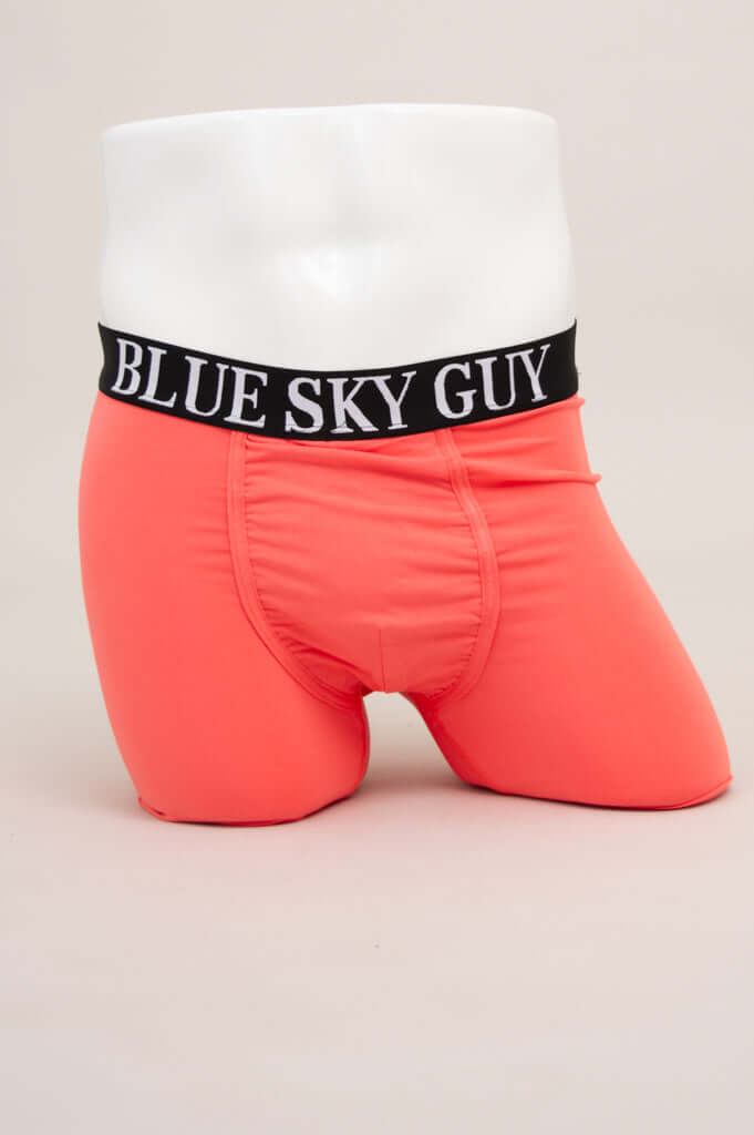 Front view of coral men’s boxer briefs with black 'BLUE SKY GUY' waistband on mannequin