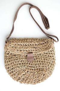Front view of hand woven rattan purse with leather strap and clasp