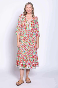 Front view of woman wearing a colorful floral batik midi dress with 3/4 sleeves
