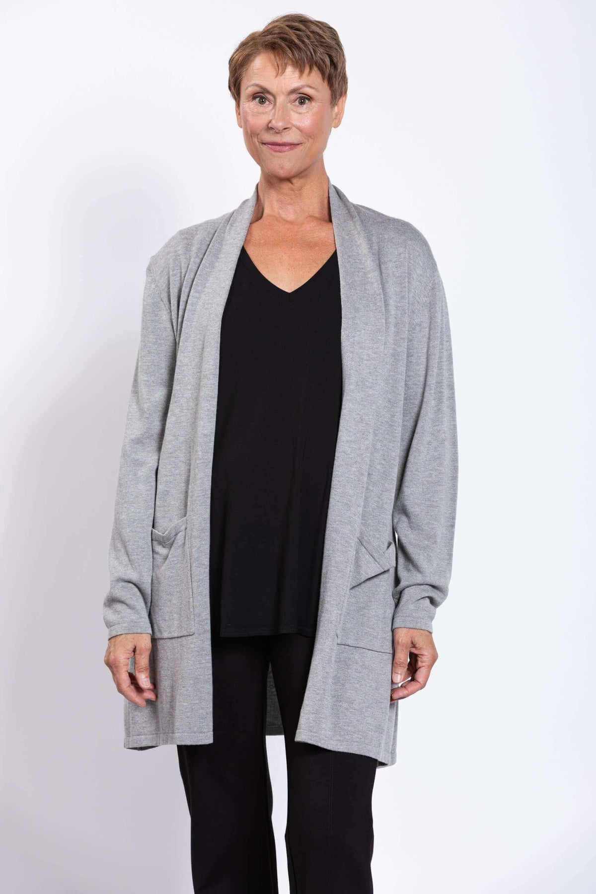 Front view of a woman wearing a light grey open-front cardigan over a black top