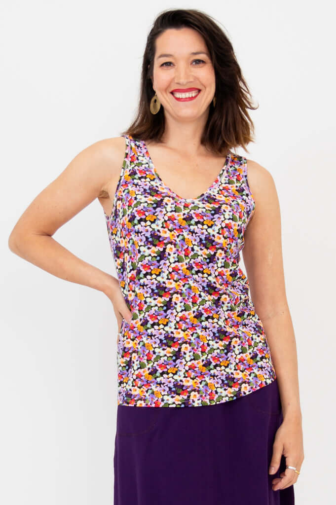 Woman wearing Reanna reversible bamboo tank with violet floral print and purple skirt, front view