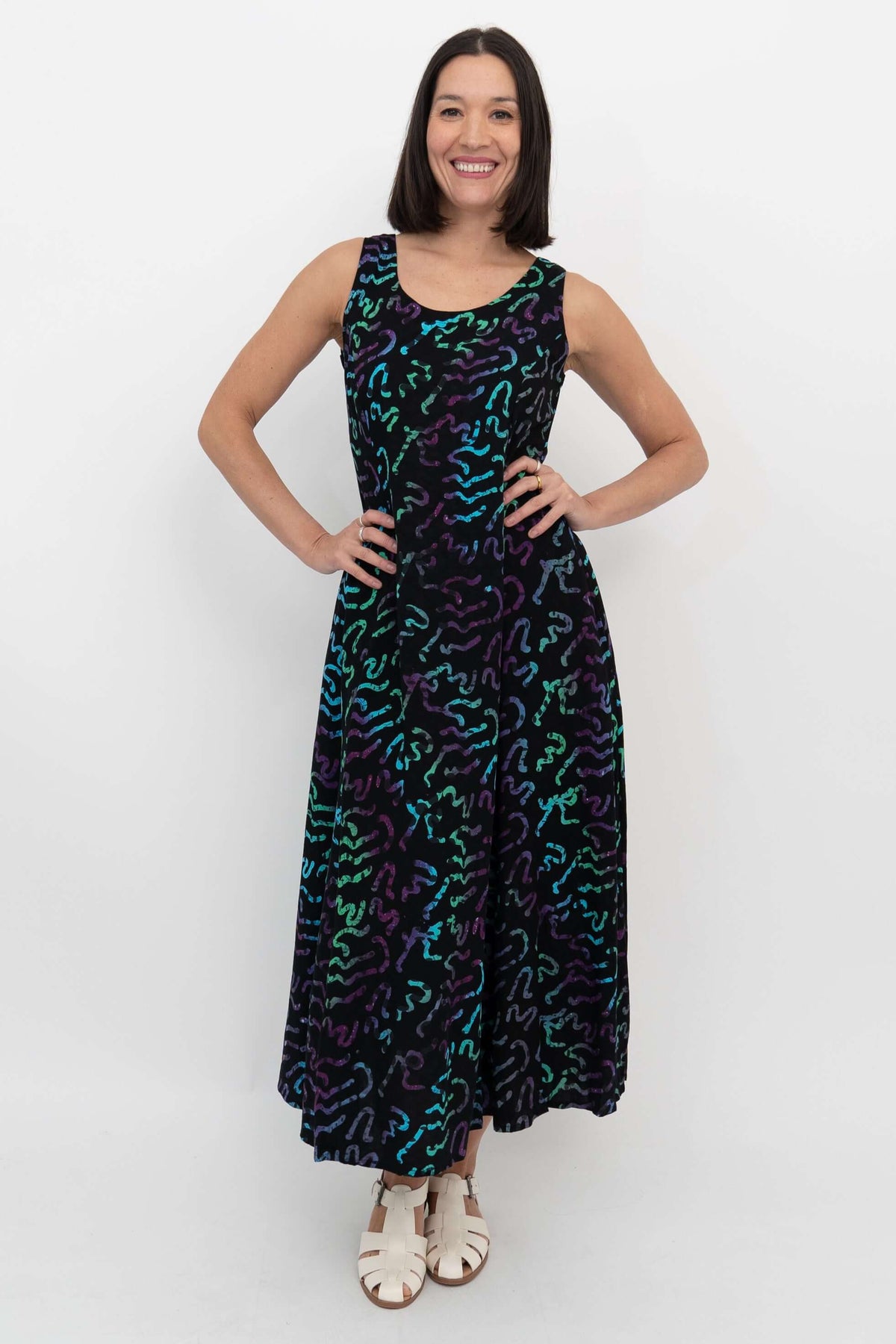 Front view of woman wearing a black maxi dress with neon wave pattern