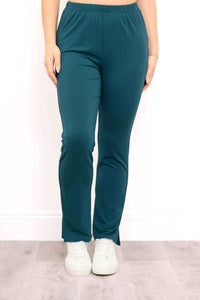 Front view of teal bamboo slim-fit pants with ankle slits and elastic waist, worn with white sneakers