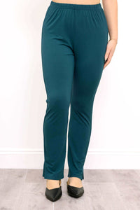 Front view of teal bamboo slim-fit pants with ankle slits and elastic waistband, styled with black flats