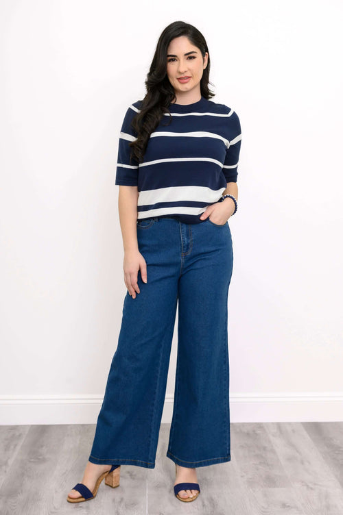 Front view of woman wearing navy and white striped crew neckline sweater with wide-leg jeans